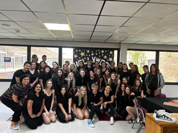 From the 2023 Annual Shoe Fashion Show organized by Ms. Perla and her students. Perla is front and center showing off her blue kicks desiged and created by 2023 graduate Elise Newbury.