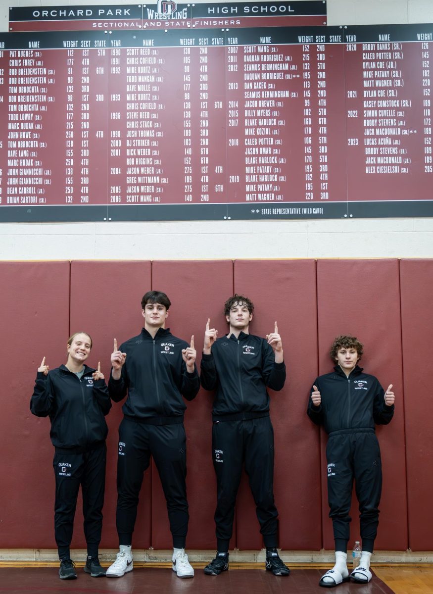 Senior wrestlers for 2024 show pride in their banner.