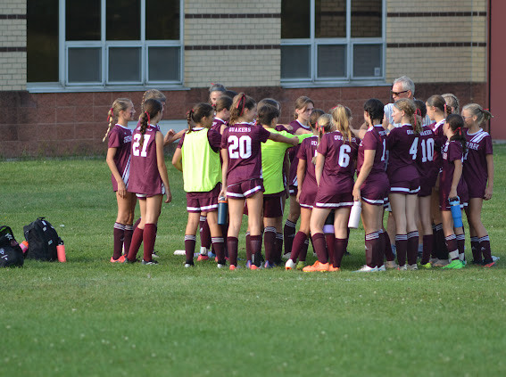 Orchard Park Girls Modified Soccer having a team talk at half-time.