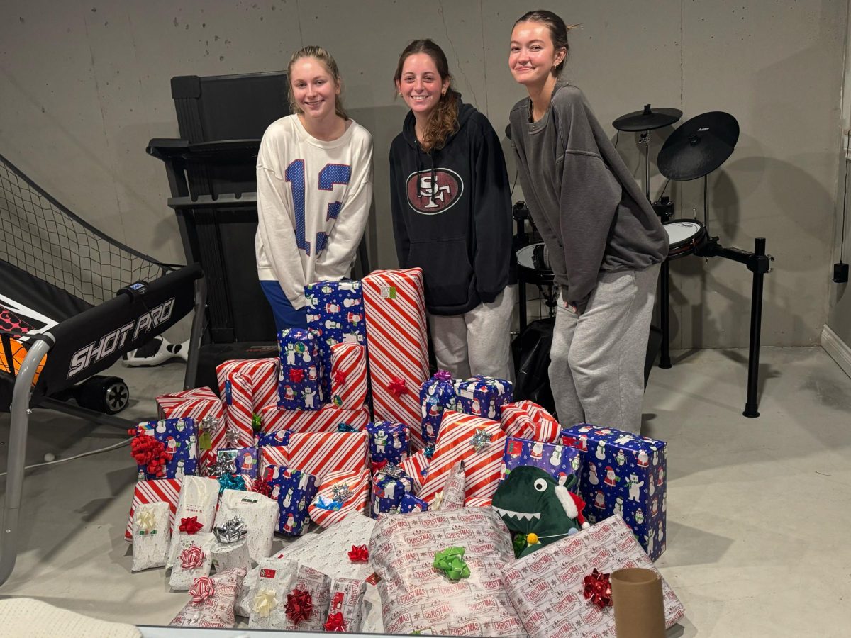 Cancer Awareness Club officers wrap gifts for Adopt-a-Family. Pictured from left to right: Lana Hollins, Eva Gross, and Lindsey Howard.