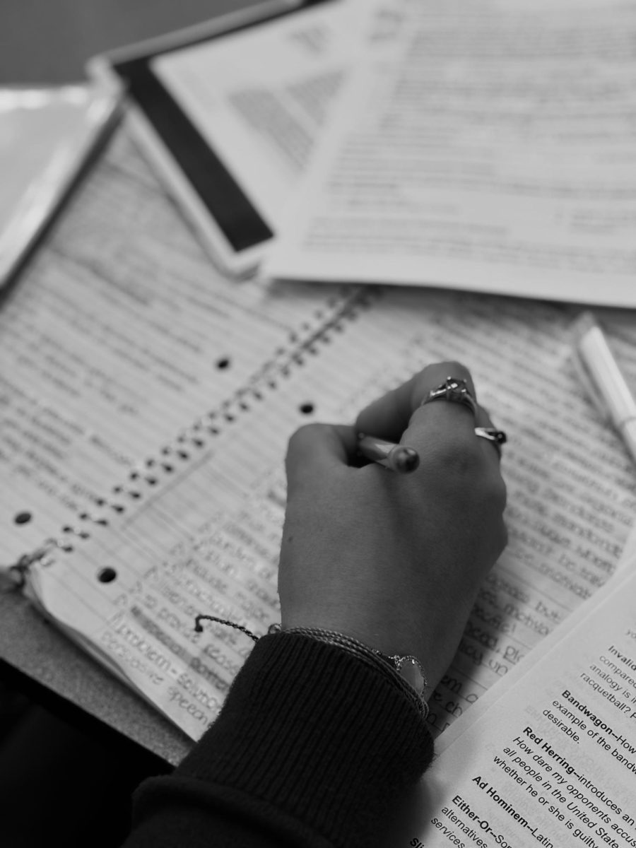 Seizing opportunities, one page at a time. Sitting in the cafeteria is a girl who is studying very intensively. Ella, a student at OP, is a very academic student.  Here she's preparing for her upcoming exam. Her hands tell the story.  

