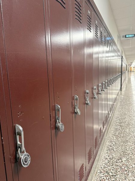 A row of lockers bearing backwards locks indicating they are presently unassingned to students.